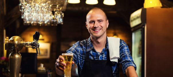 Man serving a pint from behind a bar