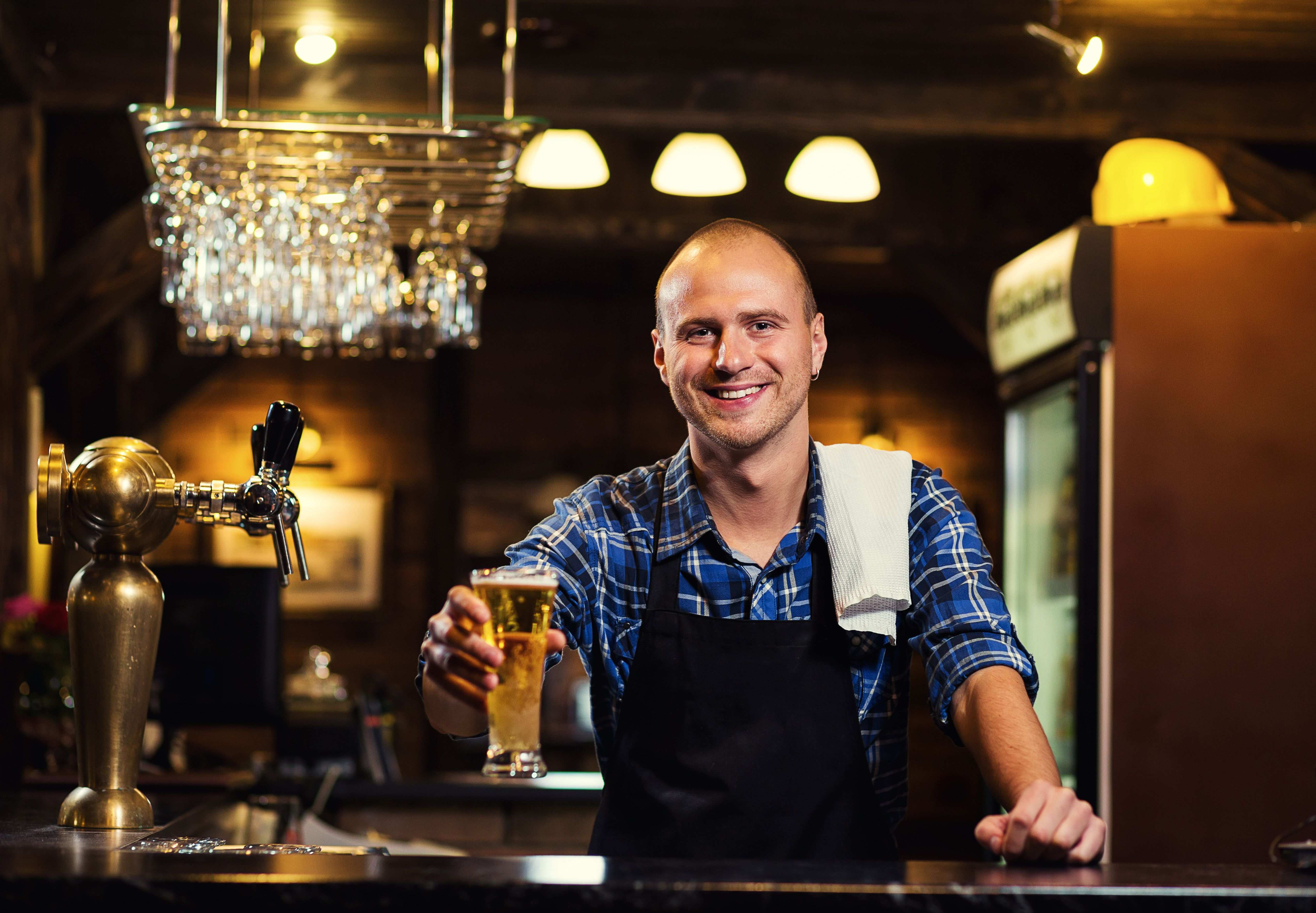 Man serving a pint from behind a bar
