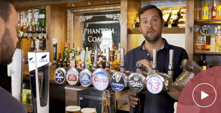 Man standing behind a bar pulling a pint image