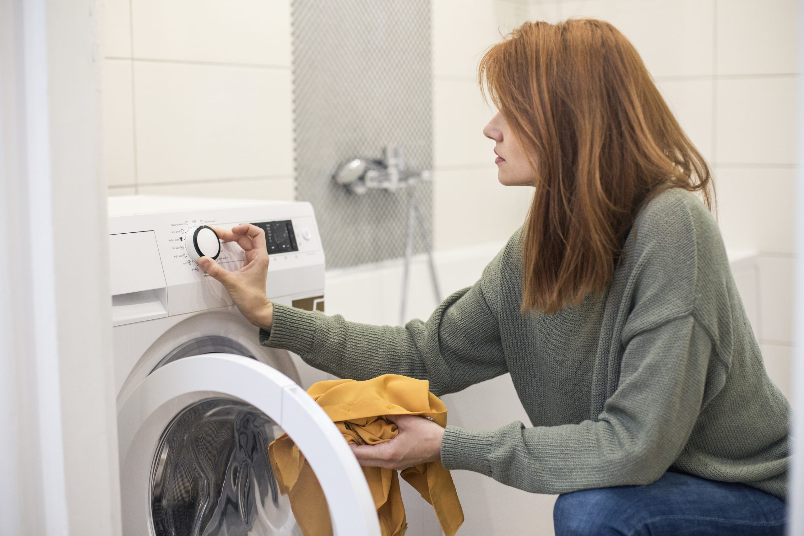 Young woman setting a washing machine