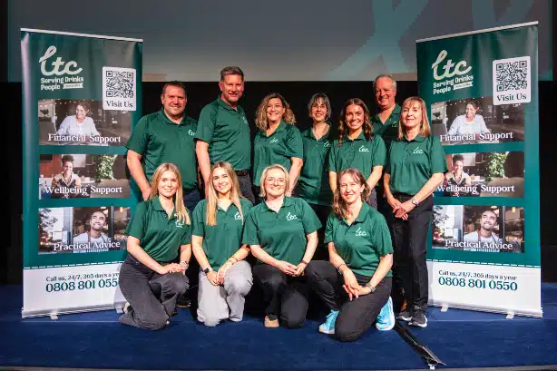 Group photo of Licensed Trade Charity team members in green shirts, promoting financial, wellbeing, and practical support.