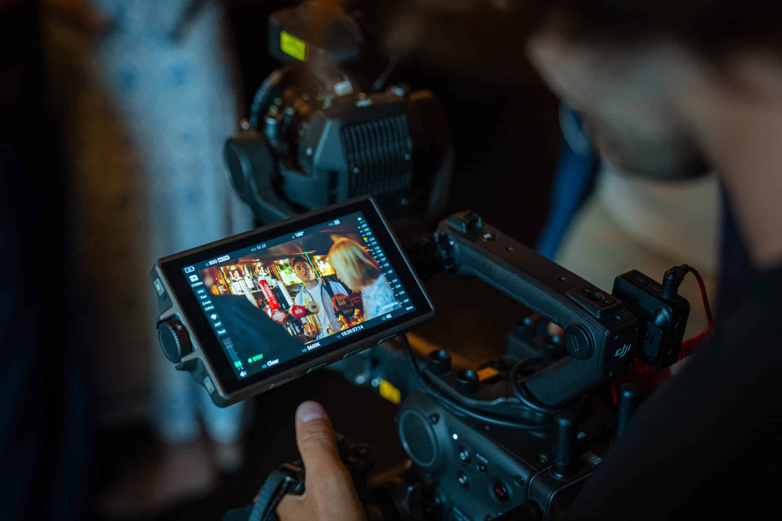 Filmmaker monitors camera footage on screen, always on shift.